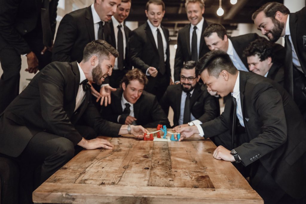 the boys have fun playing rock n sock em robots before the wedding