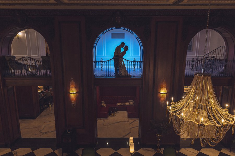 A bride and groom pose for a silhouette picture in the archways with blue lighting at the Read House historic wedding venue.
